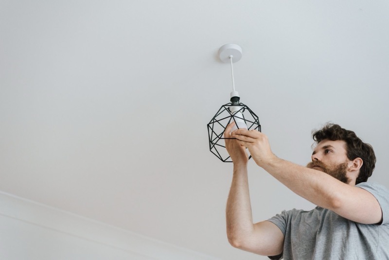 An electrician fitting a pendant light