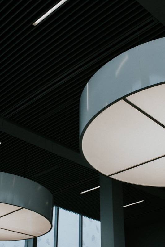 Large round pendant lights in an office ceiling